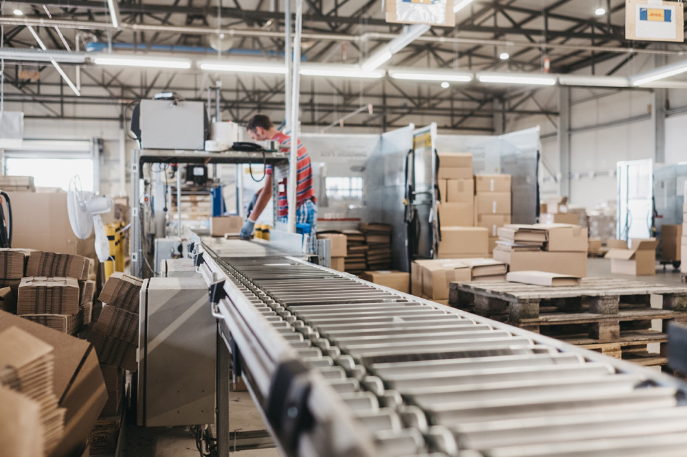 Förderband mit Versandkartons im modernen Logistikzentrum