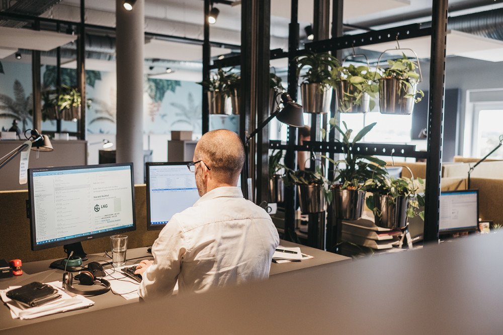 Service-Mitarbeiter arbeitet im modernen Büroarbeitsplatz bei agorando
