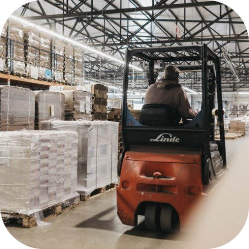 Mitarbeiter fährt Gabelstapler im Lagerbereich im Logistikzentrum