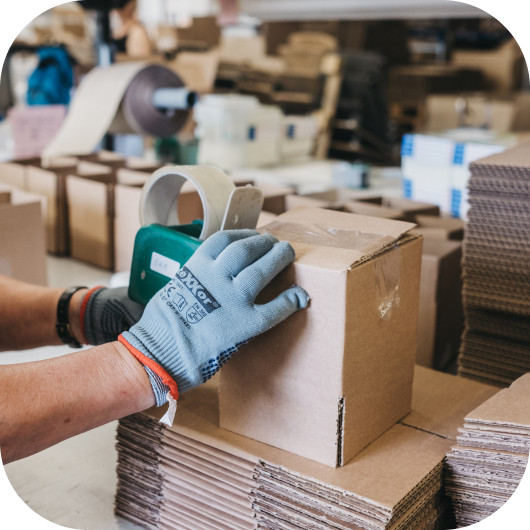 Mitarbeiter verpackt Versandkartons im Lagerbereich